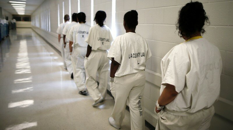 Women walk along a corridor at the Los Angeles County women's jail in Lynwood, California April 26, 2013. The Second Chance Women's Re-entry Court is one of the first in the U.S. to focus on women, and offers a cost-saving alternative to prison for women who plead guilty to non-violent crimes and volunteer for treatment. Of the 297 women who have been through the court since 2007, 100 have graduated, and only 35 have been returned to state prison. REUTERS/Lucy Nicholson (UNITED STATES - Tags: CRIME LAW) - RTXZ1G4