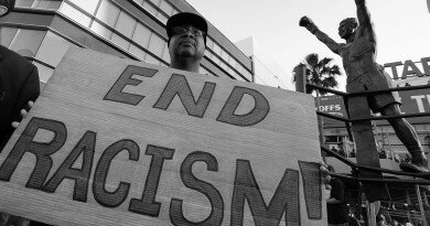LOS ANGELES, CA - APRIL 29: Dexter McLeod holds a sign protesting racist comments made by L.A. Clippers owner Donald Sterling outside Staples Center before a playoff game on April 29, 2014 in Los Angeles, California. Clippers owner Donald Sterling was banned for life today by the NBA and barred from having any association with the team and ordered to pay a $2.5 million fine. (Photo by Jonathan Alcorn/Getty Images)